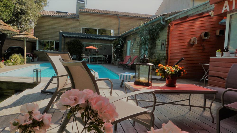 L'extérieur avec la piscine, des transats, bains de soleil, salon de jardin, parasols, etc.