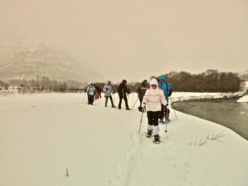 Un groupe marche en raquette au bord de l'Arc Un groupe marche en raquette au bord de l'Arc