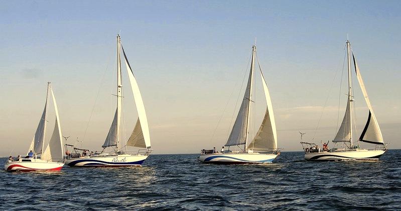 Quatre voiliers en mer en fin de journée.