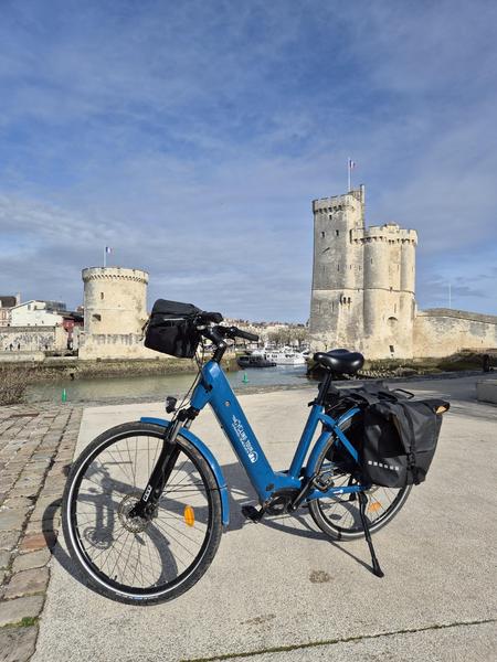 Vélo à asstsiatnte électrique devant les Tours de la Rochelle