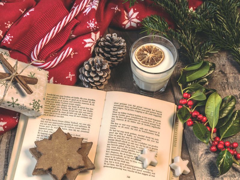 Open book surrounded by Christmas objects