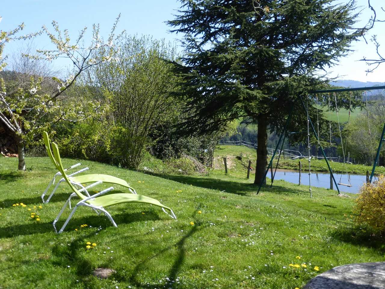 Gîte / Maison de Vacances 'La Glycine' à Meaux la Montagne en Haut Beaujolais dans le Rhône - Proximité du Lac des Sapins : le pré avec vue sur l'étang.