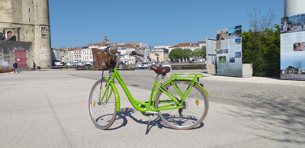 Un vélo vert au pied d'une des tours.