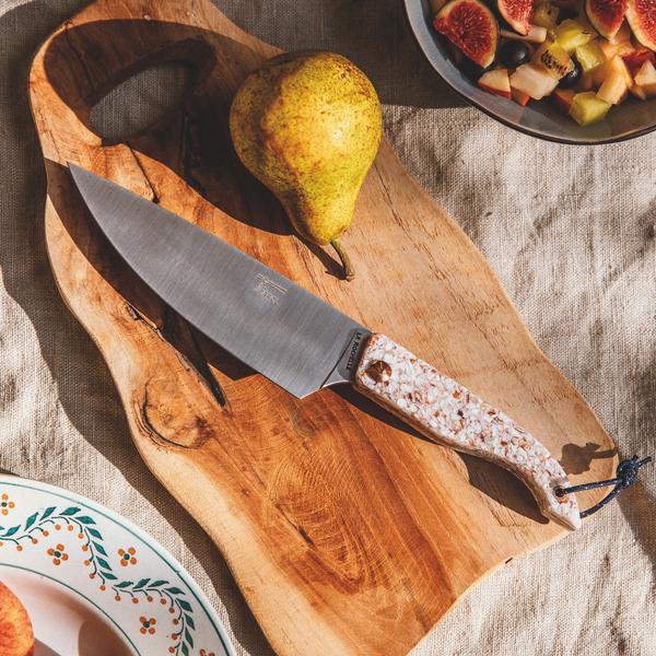 Un couteau "Encan de Cuisne polyvalent" sur une planche à découper en bois.