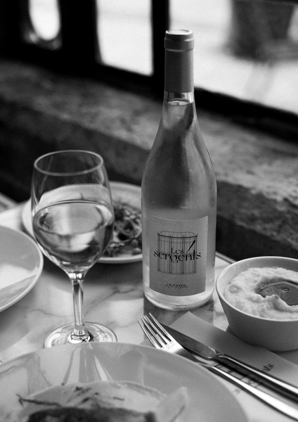 Photo en noir et blanc d'une bouteille de vin "Les 4 Sergents) et d'un verre.