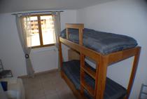 Chambre à coucher lumineuse avec lit superposé, fenêtre et rideaux