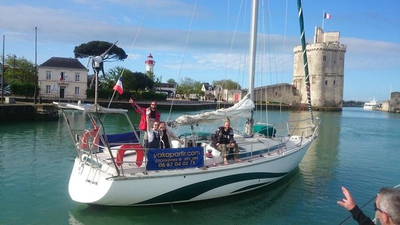 Des personnes sur un voiliers, voiles baissées, dans le Vieux-Port.