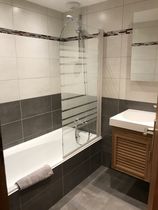 Salle de bains avec sa baignoire/douche, vasque et son meuble, miroir