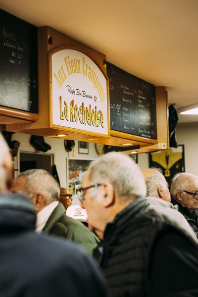 Zoom sur l'enseigne "Aux Vieux Crampons" au dessus du bar.