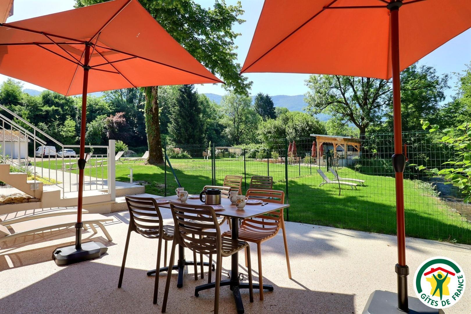Terrasse privative du gîte LYONNE avec salon de jardin et bains de soleil