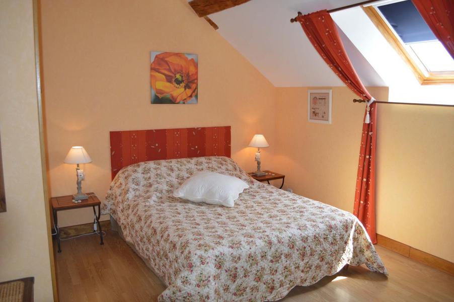La chambre abricot, dans les tons de jaune orangé, teinte douce, lit double avec tête de lit faite maison, tables de chevets et parquet collé au sol