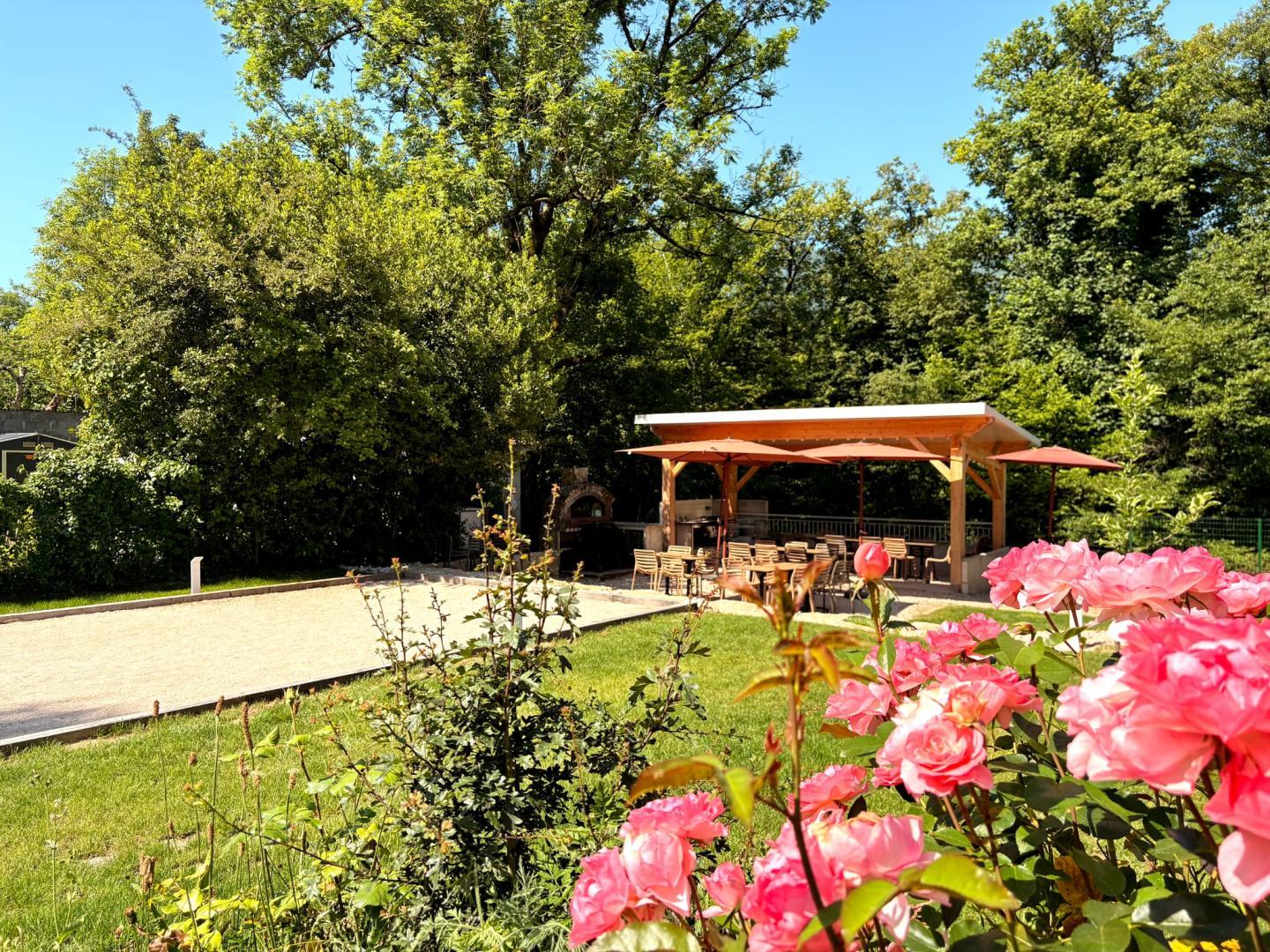 Vue sur le terrain de pétanque et la cuisine d'été à partager avec les deux autres gîtes