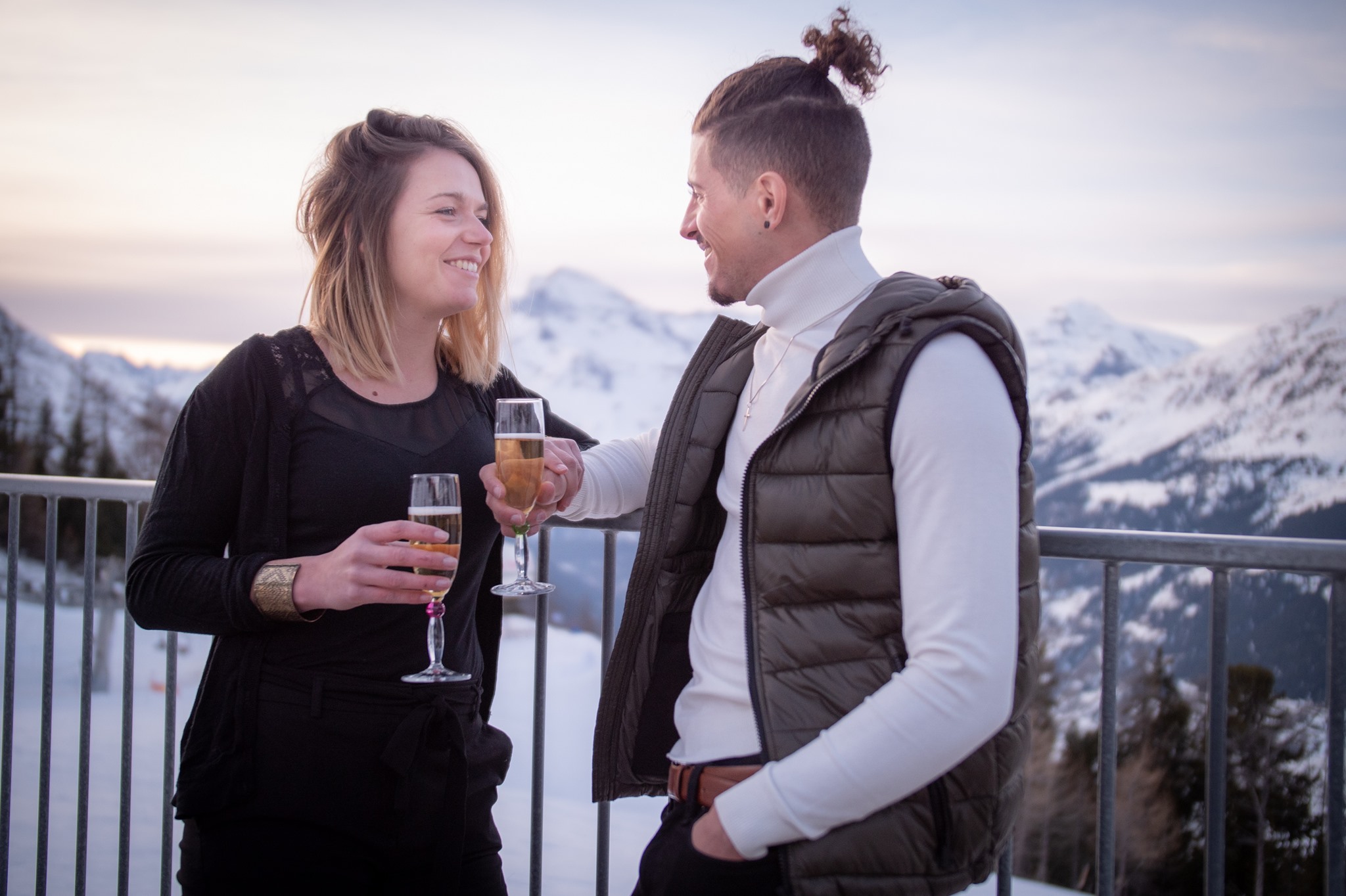 Couple sur la terrasse du chalet la Fema avec une coupe de champagne