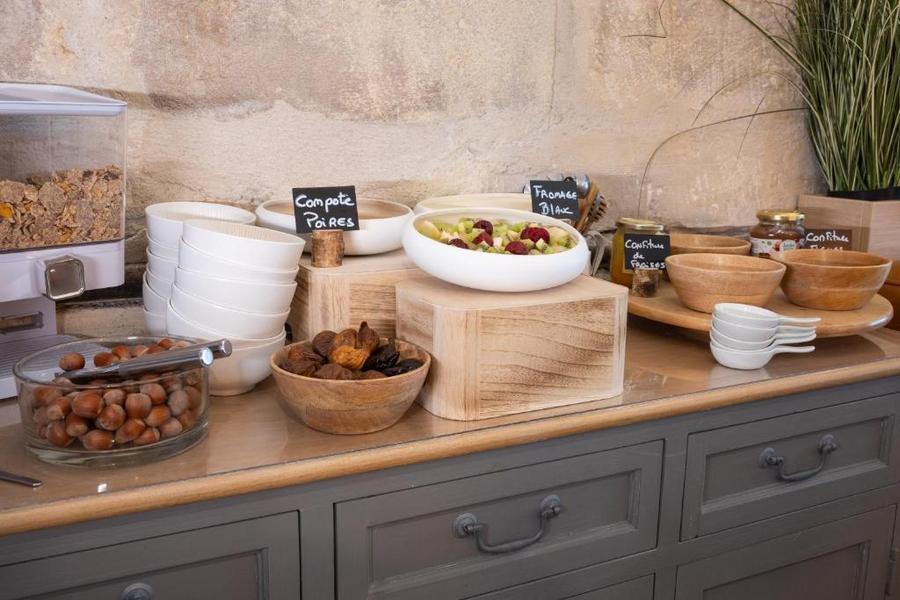 Le buffet du petit-déjeuner avec des fruits, des céréales, des confitures, etc, et de la vaisselle.
