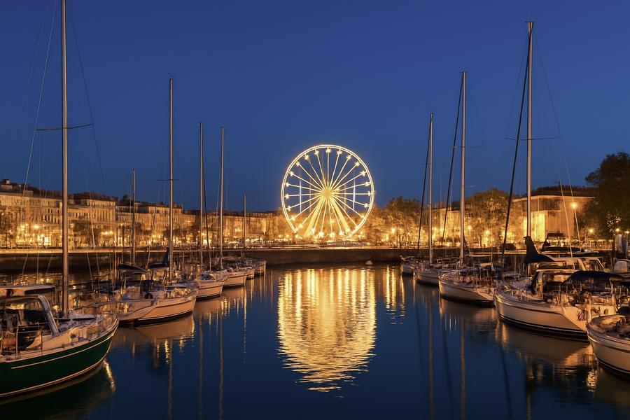 la grande roue derrière le port illuminée de nuit.