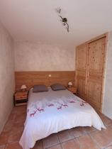 Chambre à coucher avec lit double, ameublement bois, sol carrelé