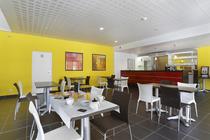 Residence hall and mess hall with dining tables, counter, tiled floor