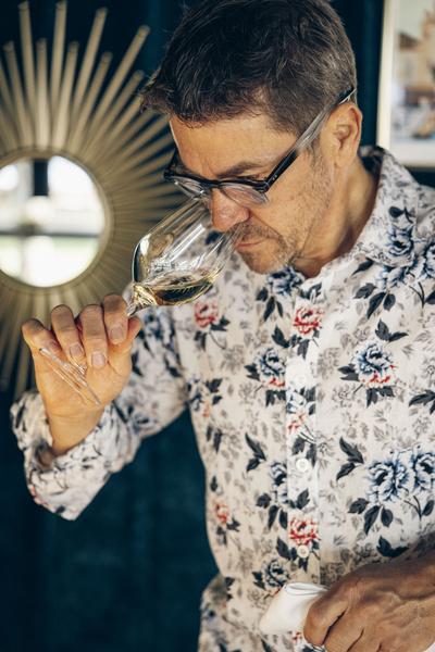 Un homme sentant un verre de vin rouge