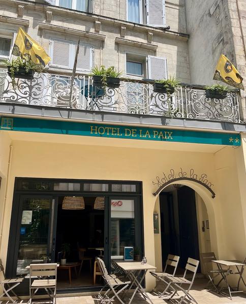 La devanture jaune avec store bleu de l'hôtel.