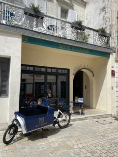 Un vélo cargo devant l'entrée de l'hôtel.