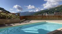 Piscine de la résidence protégée par une barrière avec vue sur les montagnes
