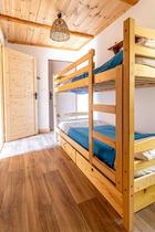 Chambre à coucher lumineuse avec lits superposés, parquet au sol