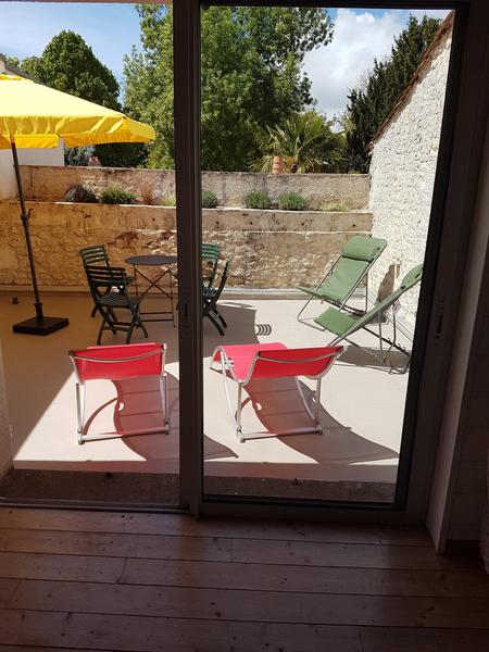 Terrasse étage avec table, chaises, et transats