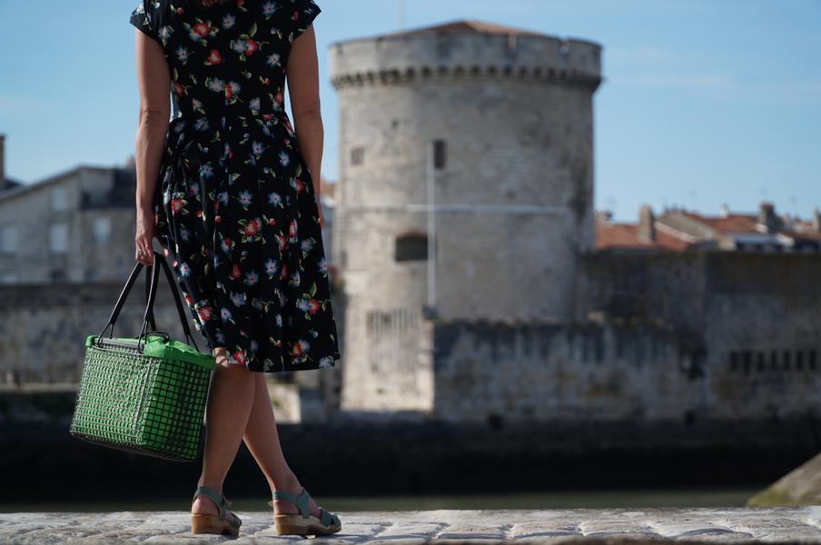 Une dame de dosi portant un panier en matière de poches ostéricole à l'intérieur vert.
