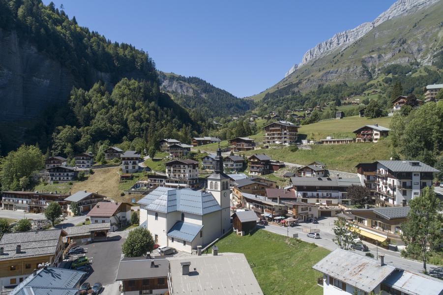 Eglise vue de haut au centre du village, la chaîne des Aravis en fond