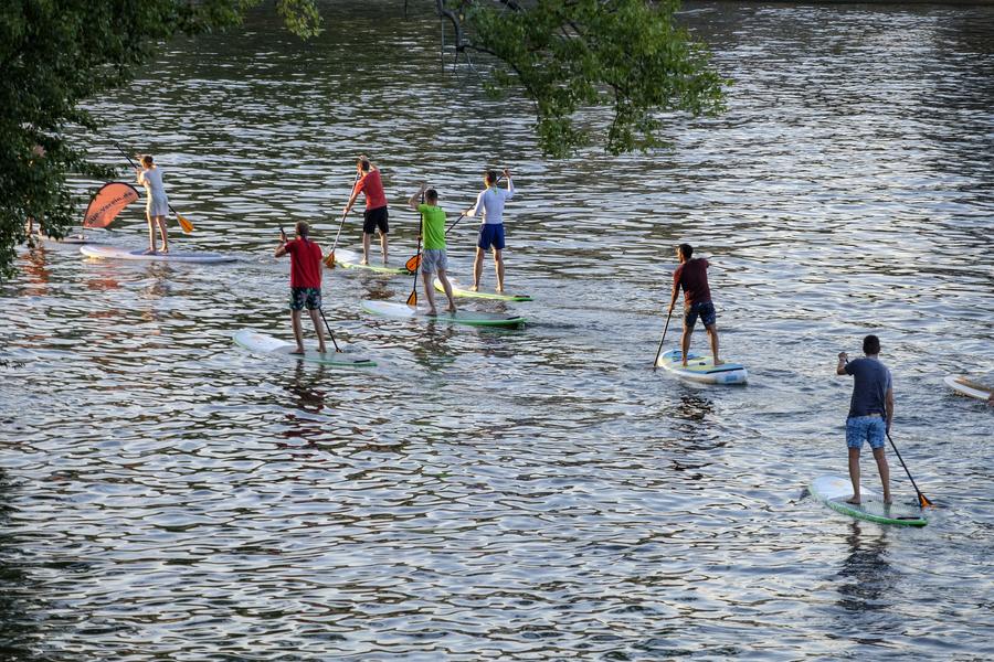 Groupe de personne faisant du stand up paddle sur une rivière 
