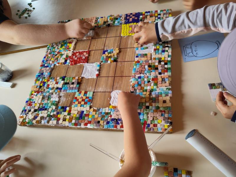 Des enfants réalisent une mosaïque