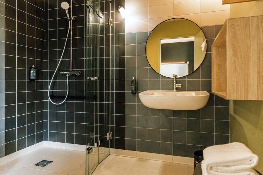 une salle d'eau avec douche à l'italienne, lavabo, miroir.