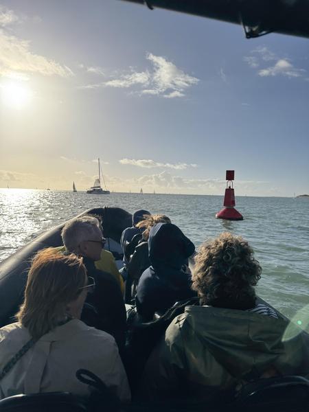 Des personnes sur un zodiac, sortant du port.