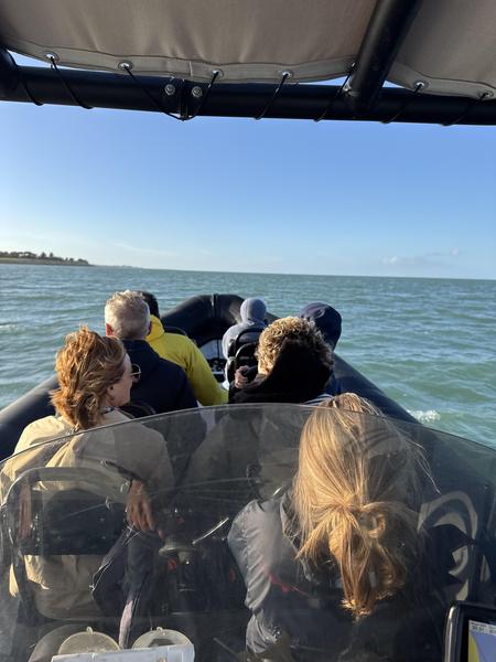 Des personnes sur un zodiac, sur l'océan.