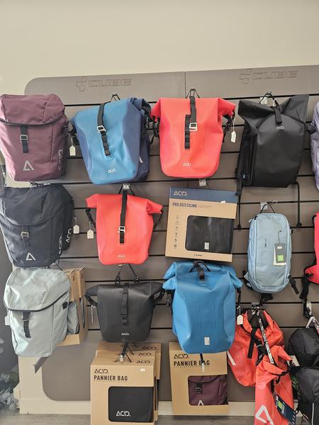 une dizaine de sacoches de vélo, de toutes les formes et de toutes les couleurs, en magasin.