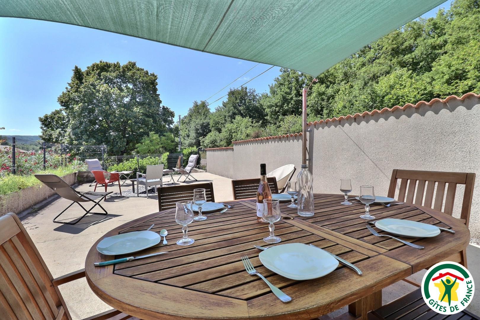 Terrasse privative : salon de jardin avec voile d'ombrage