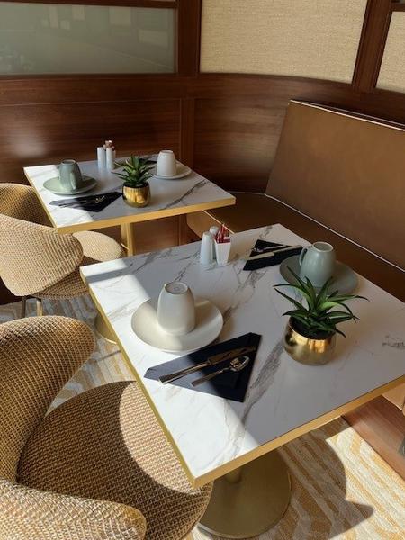 Deux tables avec chacune des tasses et couverts.