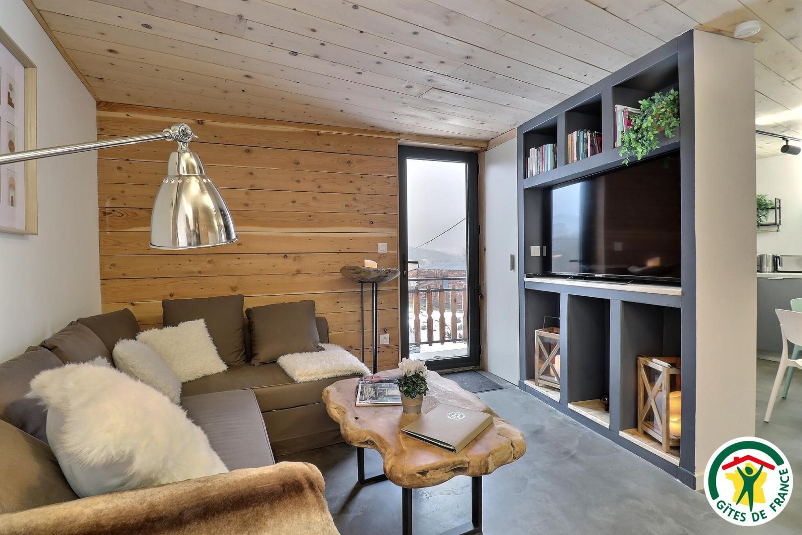 Entrée du gîte et coin salon TV avec canapé convertible (1x140)