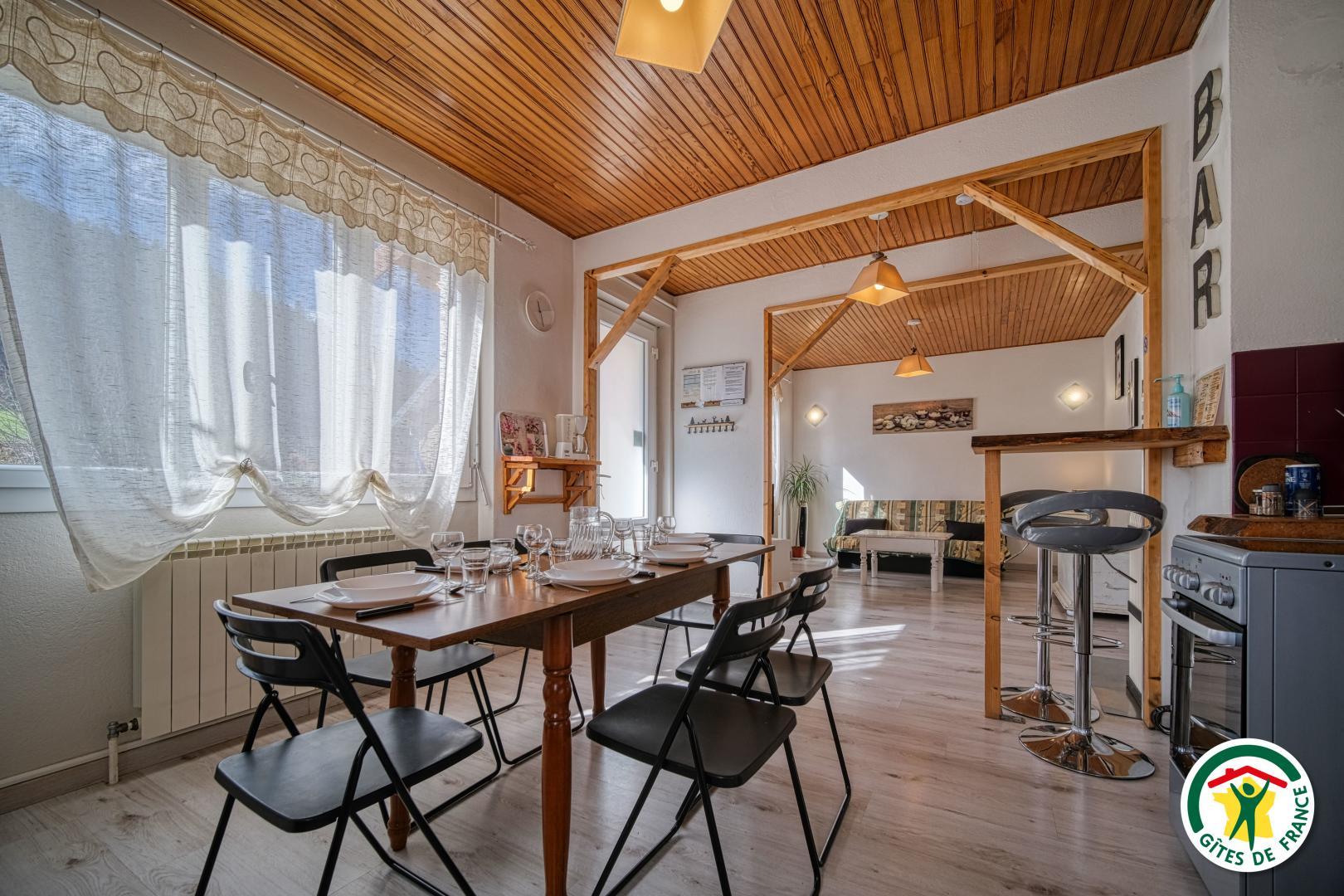 La cuisine équipée avec le coin repas, ouverte sur le salon