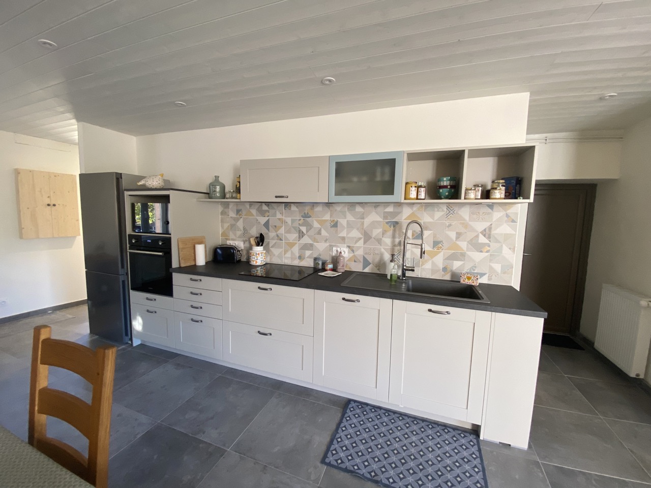Belle cuisine équipée située dans un grand espace de vie.