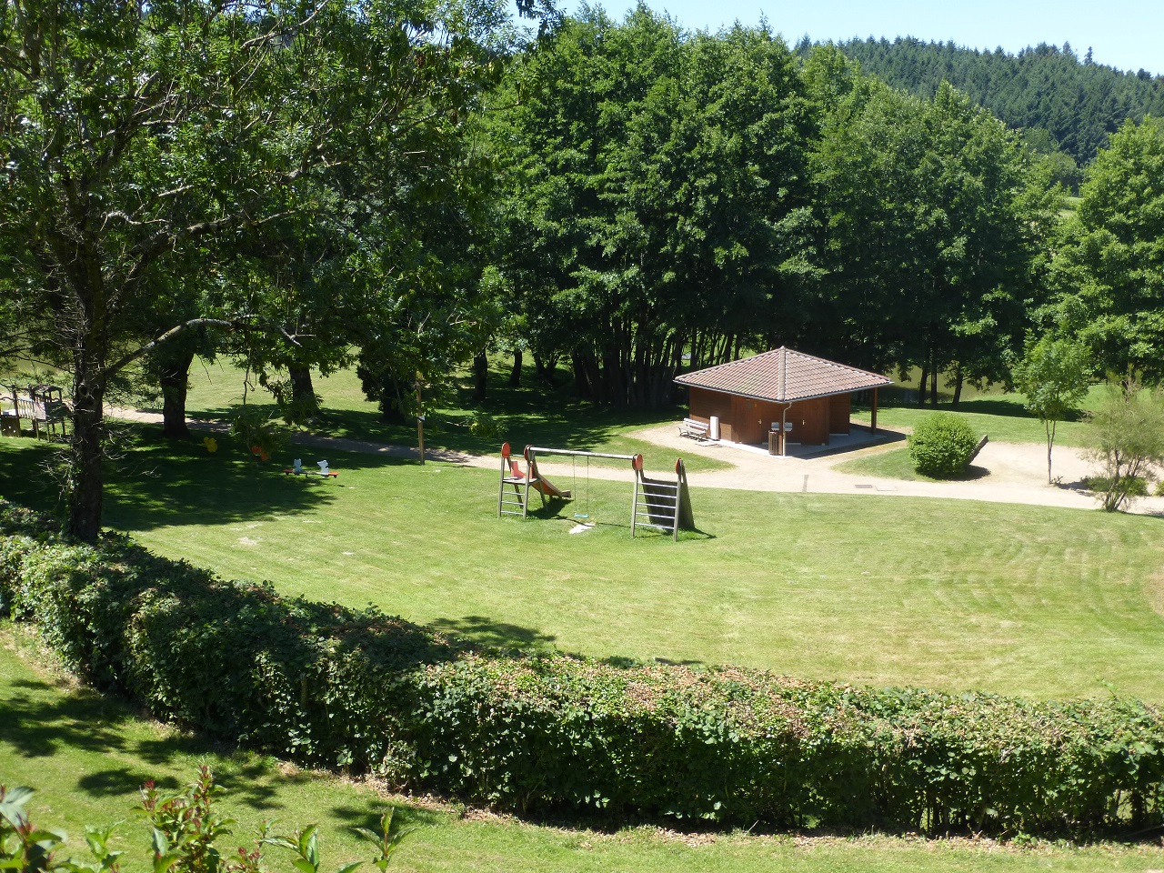 Chalet-Gîte du Plan d'eau d'Azole (Gîte N° 4) à Propières en Haut Beaujolais - proximité du Col des Echarmeaux dans le Rhône : vue sur l'aire de jeux depuis la terrasse.