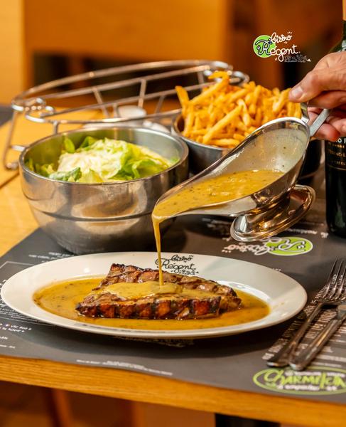 Une sauce versée sur une pièce de magret de canard grillée