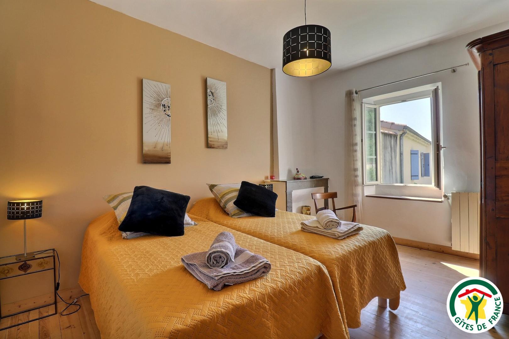 A l'étage : chambre avec deux lits simples (2x90x200), TV, salle d'eau privative (douche, lavabo)
