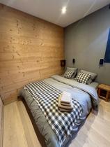Chambre à coucher avec lit double, fenêtre et intérieur bois
