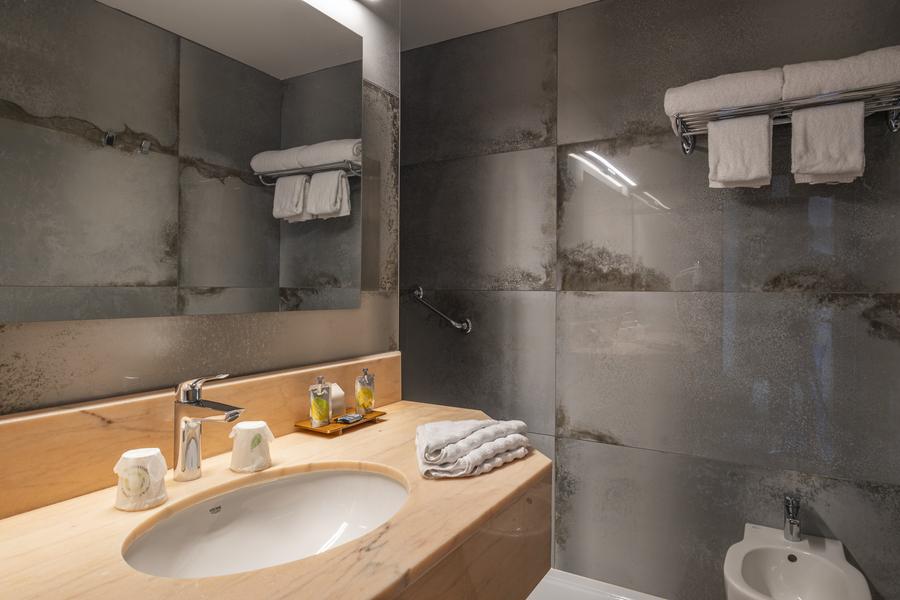 Une vasque, un miroir et un bidet.
