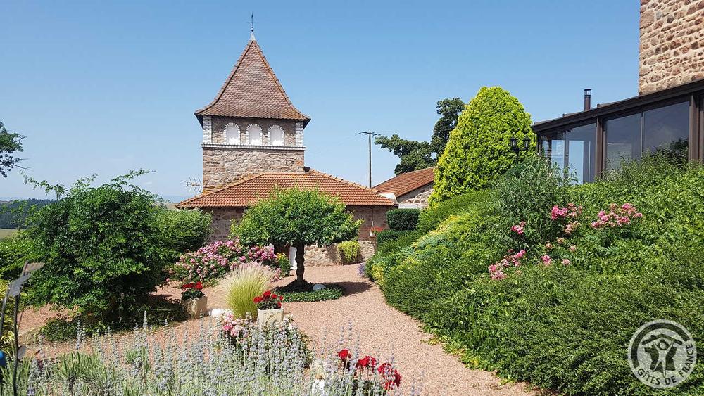 Chambres d\'hôtes \'La Ferme Fleurie\' à Thizy-Les-Bourgs, en Haut Beaujolais, dans le Rhône, proximité Roanne (42) et Lac des Sapins : le jardin fleurie et le Pigeonnier dans lequel se trouvent les Chambres d\'Hôtes.