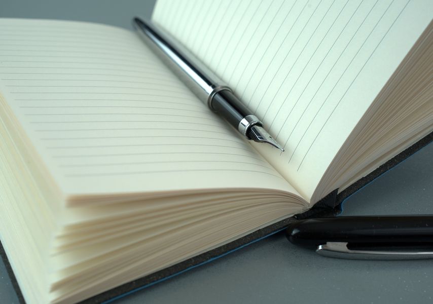 Cahier ouvert avec un stylo
