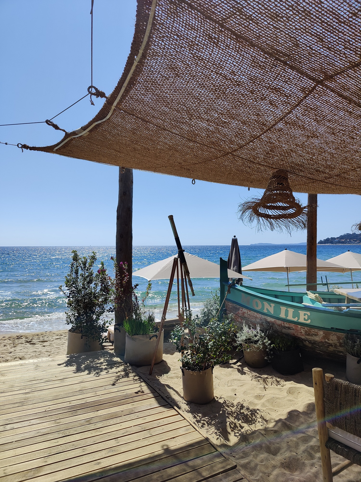 L'espace ombragé du restaurant avec parasols face à la mer