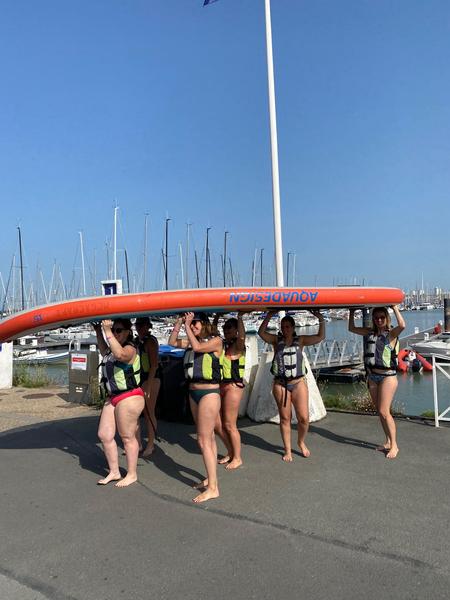 Un groupe de femme portant un paddle géant.