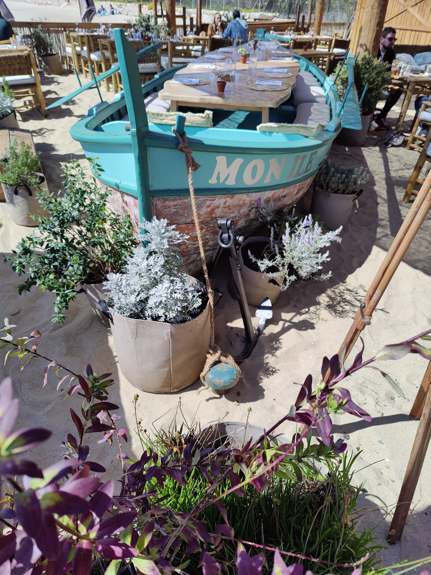 Barque turquoise au milieu des tables du restaurant
